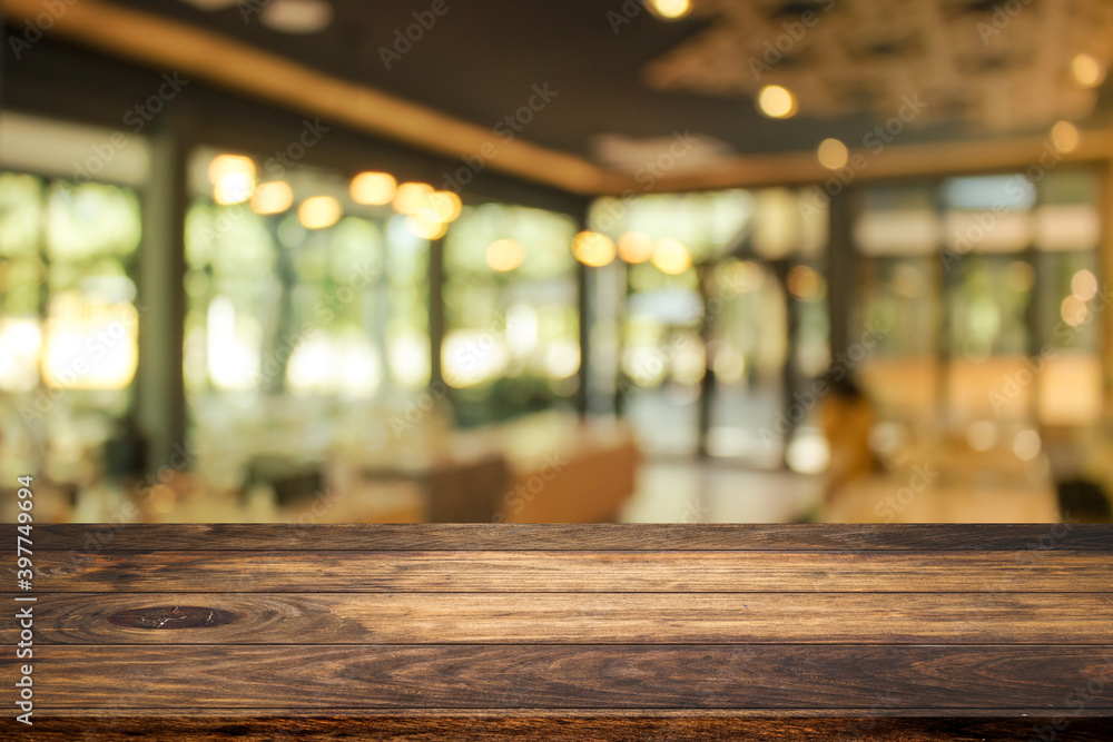 Side view of Empty space wooden table top with abstract blurry coffee shop or cafe restaurant in background for product showing and advertising. Side view of Empty space wooden table top with abstract blurry coffee shop or cafe restaurant in background for product showing and advertising.