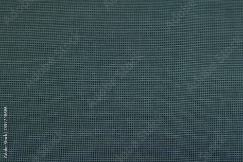 Background of dark textured wool fabric in a small cage for autumn and winter wardrobe. Horizontal orientation