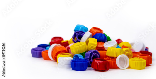 Multi-colored plastic bottle caps on a white background. Ecology and recycling concept.
