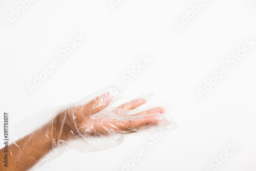 Woman hand wearing single use protect disposable transparent plastic glove, studio shot isolated on white background