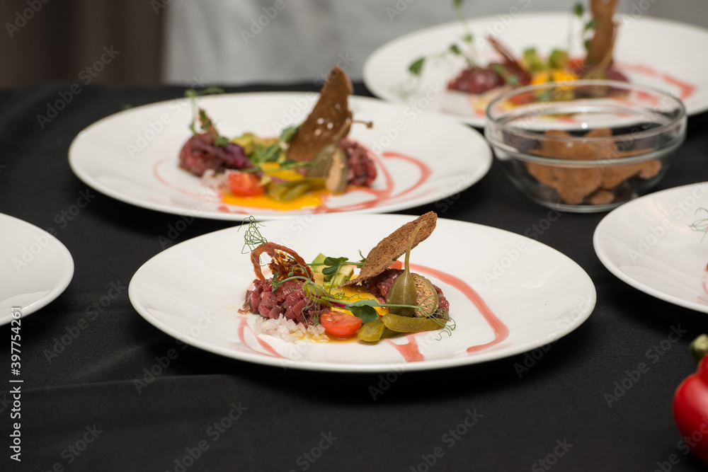 Chef pouring sauce on the Beef Tartare with Various Dip and Vegetables Chef pouring sauce on the Beef Tartare with Various Dip and Vegetables
