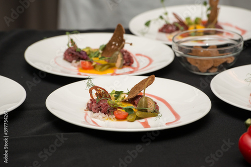 Chef pouring sauce on the Beef Tartare with Various Dip and Vegetables