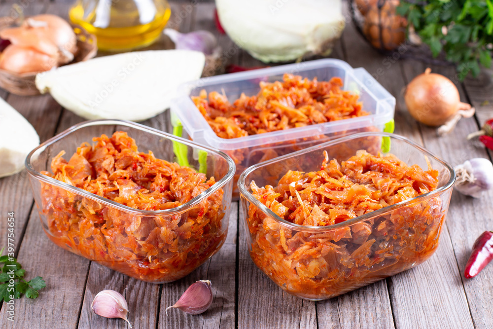 Stewed cabbage in a container on a wooden background for freezing. Frozen food, Stewed cabbage in a container on a wooden background for freezing. Frozen food,