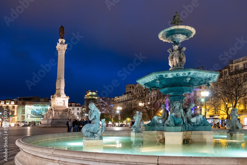 Illuminated fountain with Column of Pedro IV at Rossio Square in Lisbon, Portugal