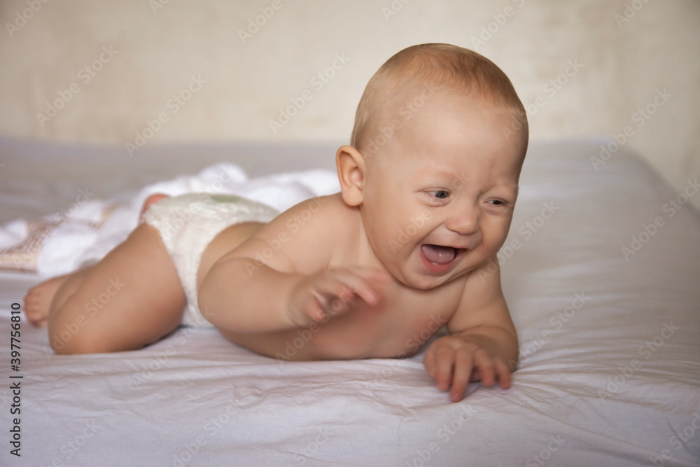 Adorable toddler laughs lying on bed Adorable toddler laughs lying on bed
