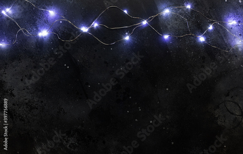 Glowing Christmas tree garland on dark background. Copy space. Christmas background. Festive background.