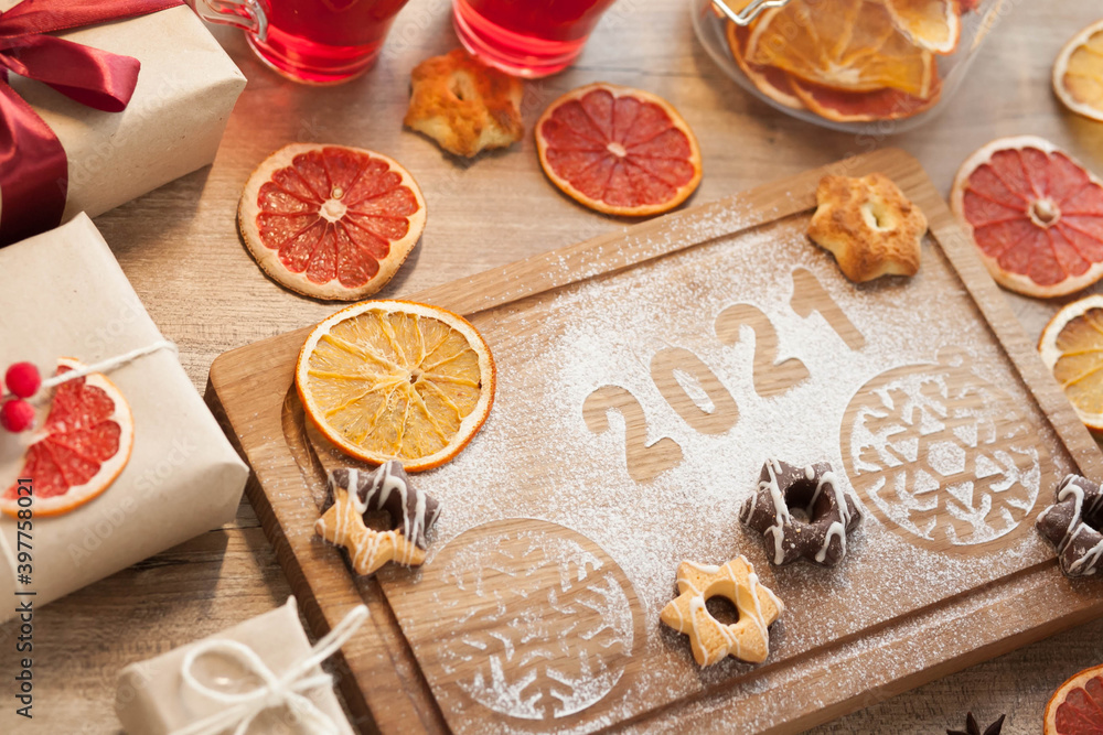 Christmas and New Year 2021 background with ingredients for cooking christmas baking decorated with fir tree. New Year's decor, homemade cookies preparing for the holiday. Christmas and New Year 2021 background with ingredients for cooking christmas baking decorated with fir tree. New Year's decor, homemade cookies preparing for the holiday.