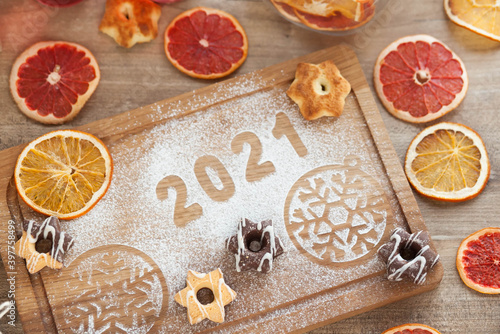 Christmas and New Year 2021 background with ingredients for cooking christmas baking decorated with fir tree. New Year's decor, homemade cookies preparing for the holiday.