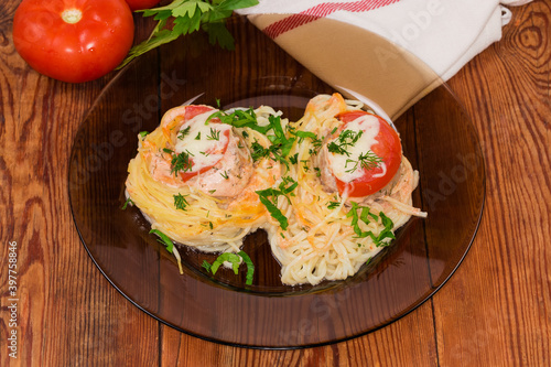 Two cooked pasta nests with chopped meat on glass dish photo