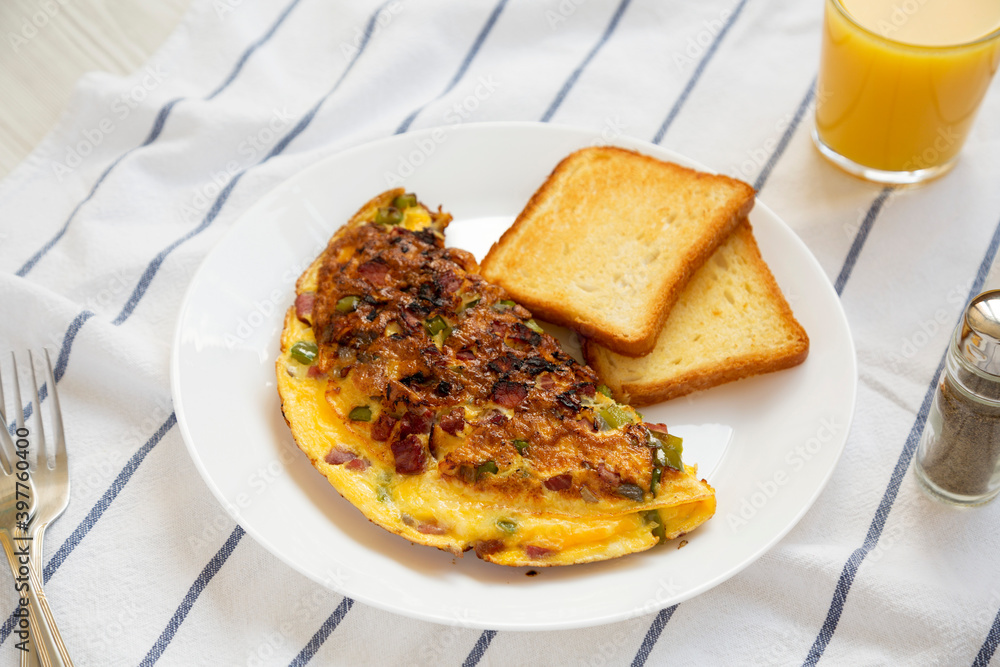 Homemade Denver Omelette on a white plate on cloth, side view. Homemade Denver Omelette on a white plate on cloth, side view.