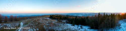panorama of winter meadow, forest and clear sky in the mountains