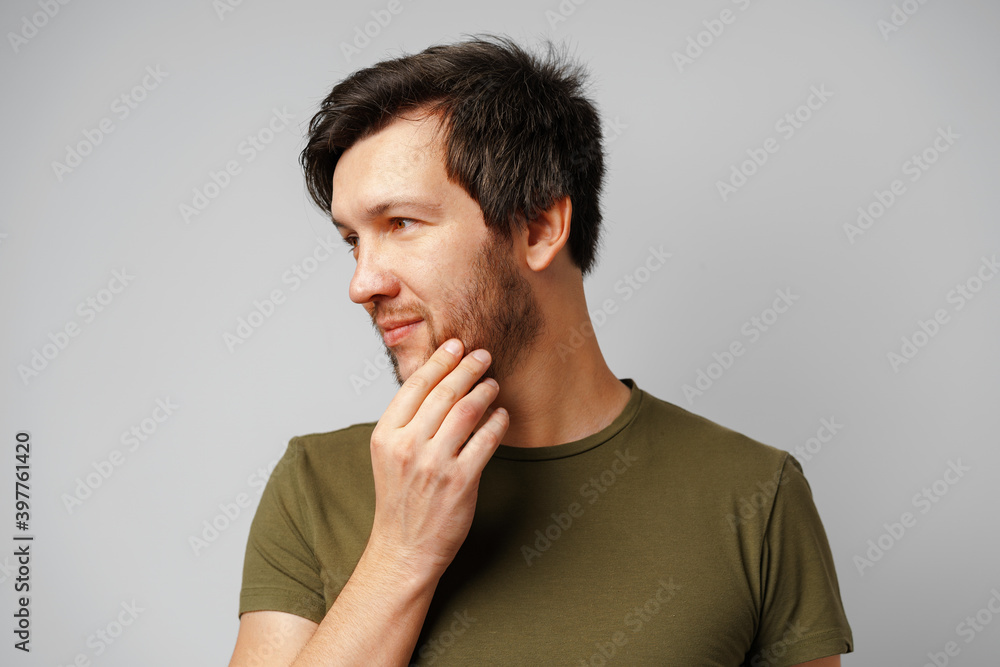 Handsome young man portrait smiling against grey background Handsome young man portrait smiling against grey background