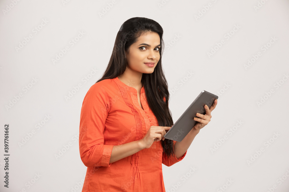 Worried Indian young woman using digital tablet on white. Worried Indian young woman using digital tablet on white.
