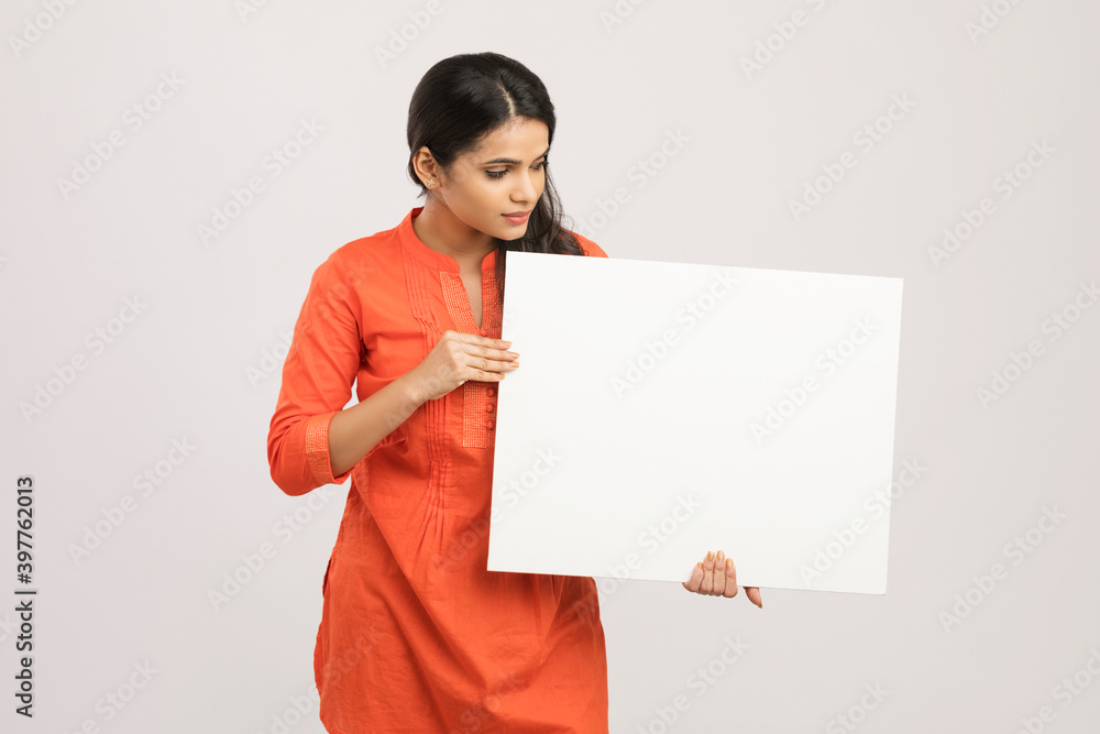 Cheerful attractive young women holding white board on white. Cheerful attractive young women holding white board on white.