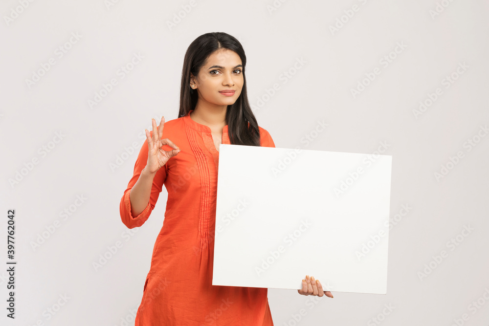 Cheerful attractive young women holding white board on white. Cheerful attractive young women holding white board on white.