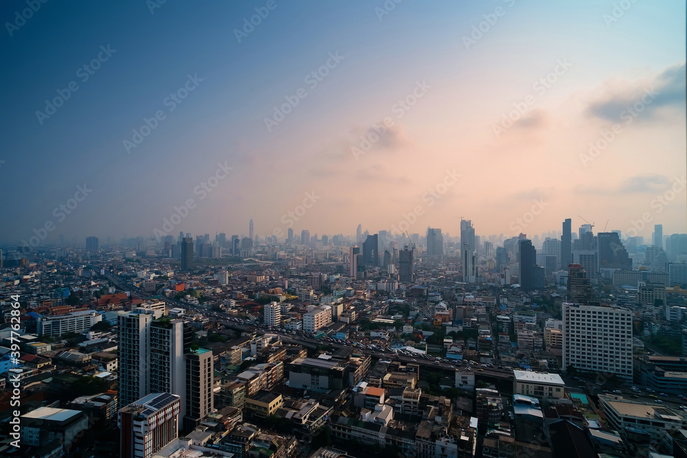 Cityscape photo show traffic jams on the highway of a big city in evening cover by dust mist that made two color sky