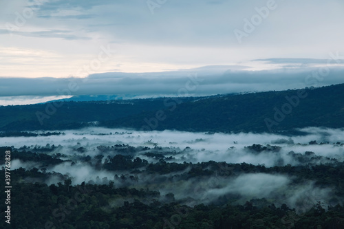 morning mist cover the forest villages between mountains with cloudy orange sunrise sky © photopk