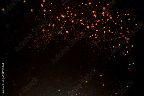 Abstract gold and red blurred sparkles on black background