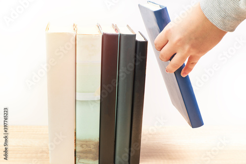 Woman taking a reading book that is on a table. Concept education photo