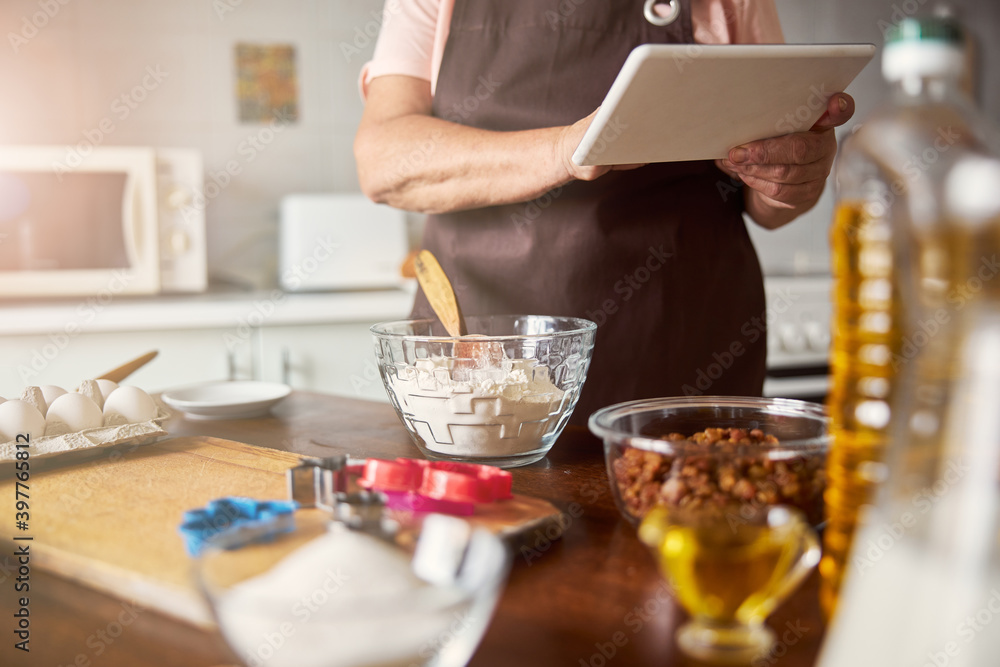 Modern cook checking a recipe online before cooking Modern cook checking a recipe online before cooking