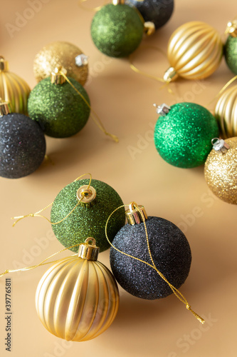 green gold and blue Christmas baubles on a beige background