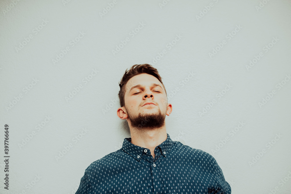 Obraz premium a stressed caucasian businessman wearing a blue shirt and prescription glasses grabs his head and gets annoyed in his office.