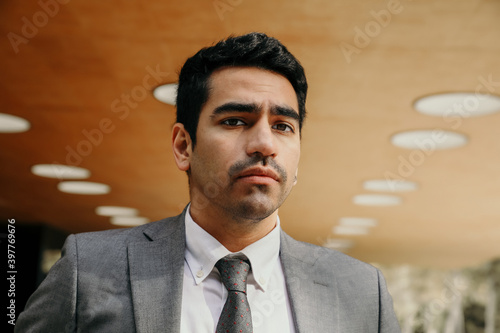 Businessman while walking outdoors with office building in the background. 