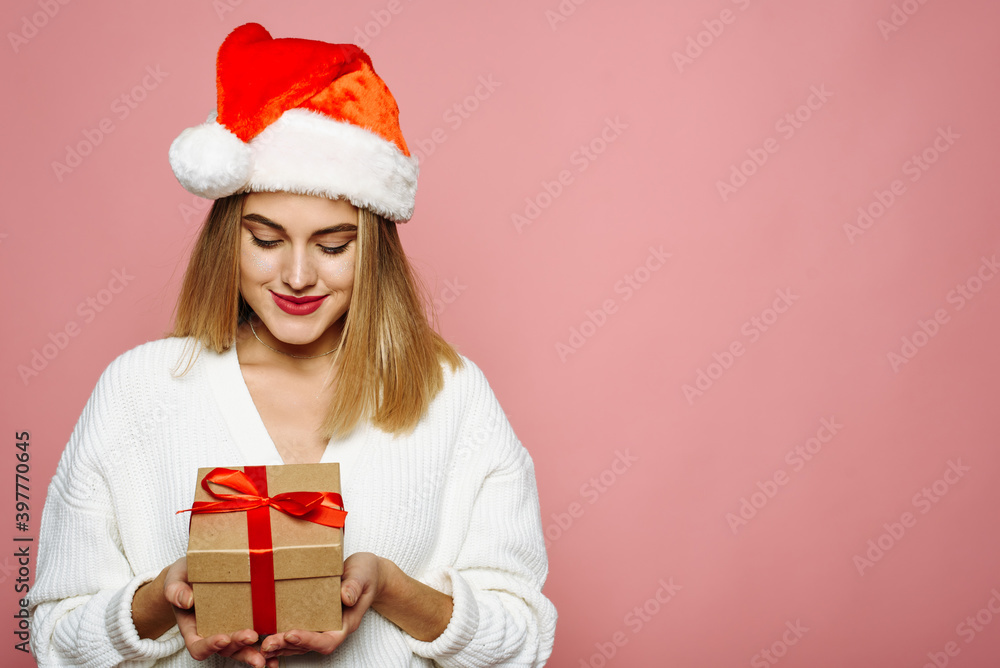 Portrait with copy space, empty place of pretty charming elegant girlfriend celebrating christmas, opening packed gift box isolated on pink background Portrait with copy space, empty place of pretty charming elegant girlfriend celebrating christmas, opening packed gift box isolated on pink background