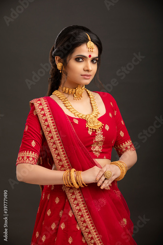 Photography Pretty Indian young Hindu Bride against grey background.