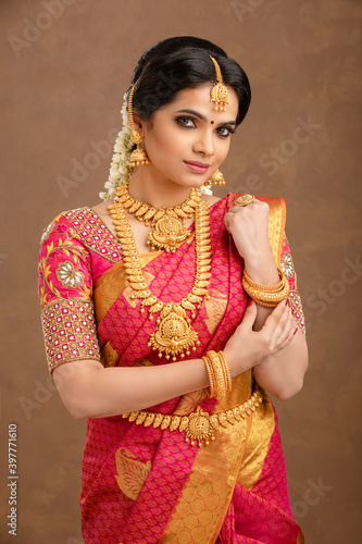 Photography Beautiful Indian young Hindu Bride against brown background in studio shot