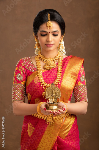 Photography Hindu Indian young bride holding Deepa in studio shot.