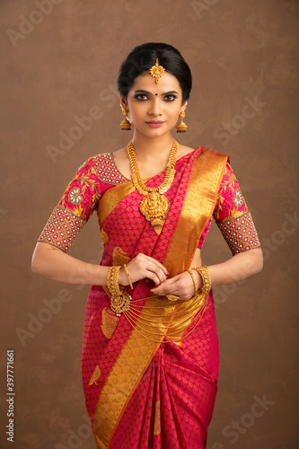 Photography Beautiful Indian young Hindu Bride against brown background in studio shot