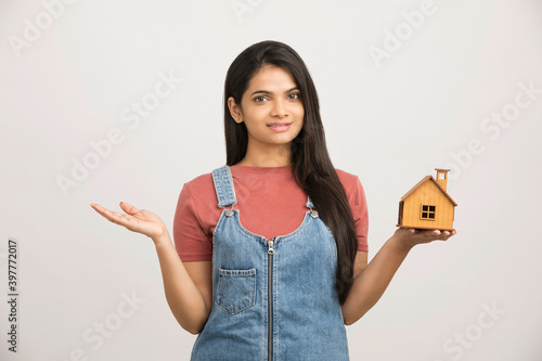 Photography Cute woman holding an house model on white