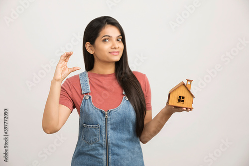 Photography Cute woman holding an house model on white