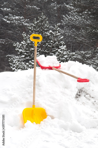 Snow removal. Red plastic Shovel in snow, ready for snow removal, outdoors. 