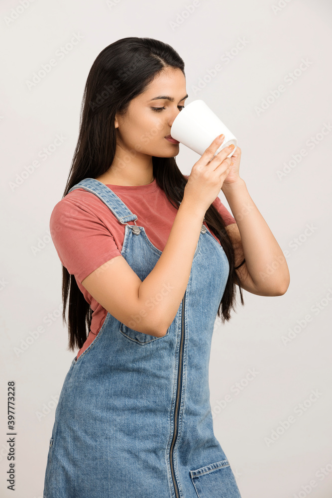 Cheerful young Indian women drinking coffee cup on white. Cheerful young Indian women drinking coffee cup on white.