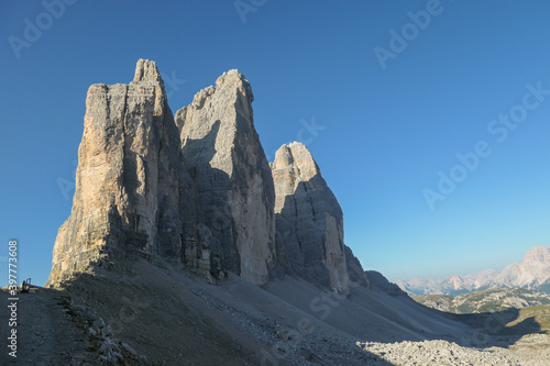 Capture of the Tre Cime di Lavaredo (Drei Zinnen) in Italian Dolomites. The mountains are catching the first sunbeams of the day. There is a lot of landslides. Natural wonder. Discovery and adventure