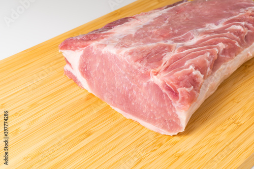 Raw boneless pork loin or pork chop on cutting board.