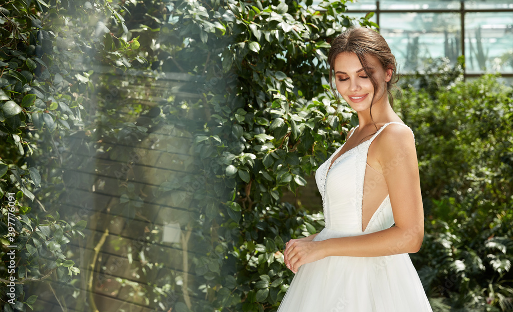 Beautiful sexy woman model bride wearing white long silk and lace wedding dress fashion espousal bright makeup brunette hairstyle ceremony in green summer garden love. Beautiful sexy woman model bride wearing white long silk and lace wedding dress fashion espousal bright makeup brunette hairstyle ceremony in green summer garden love.