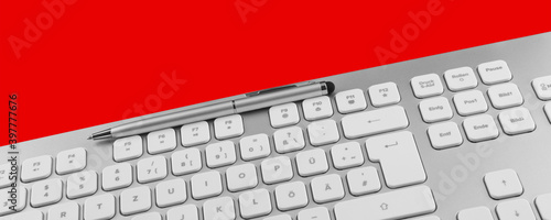 Keyboard and pen against red background photo