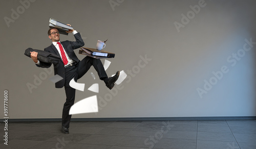 Gestresster Angestellter balanciert Akten durchs Büro photo