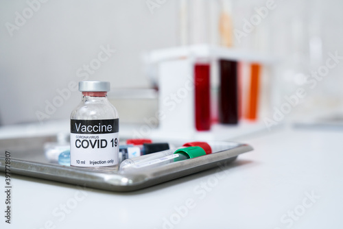 Vaccine bottle on desk of scientist for research in hospital healthcare
