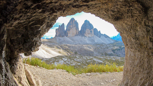 A view from inside a cave on the Tre Cime di Lavaredo (Drei Zinnen) in Italian Dolomites. Peaceful scenery. Steep and sharp mountain peaks. Sunny day. Sneak peaking. Serenity and meditation © Chris