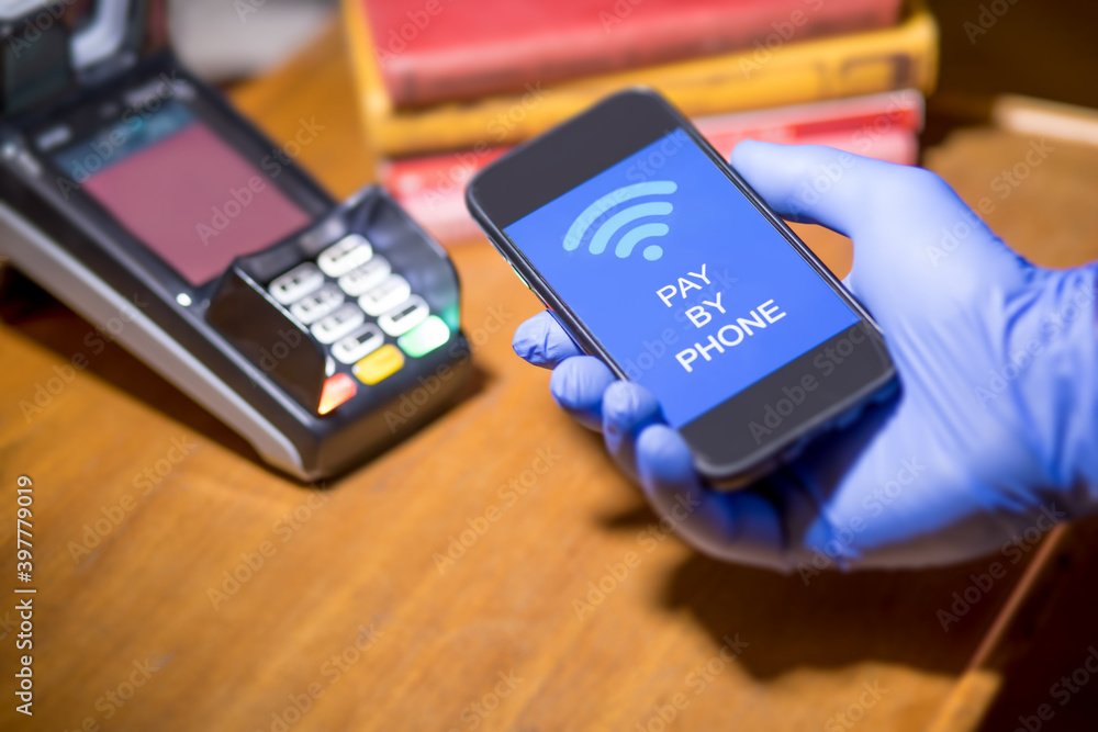 gloved hand paying with pay by phone system gloved hand paying with pay by phone system