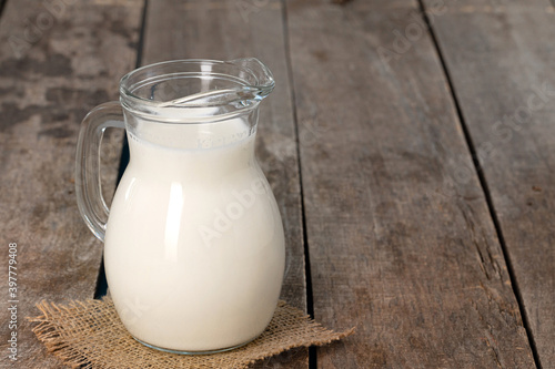 Glass jar of milk on old wooden table