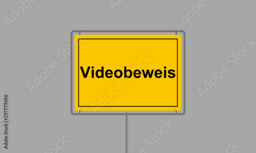 Gelbes Ortsschild mit dem Wort Videobeweis vor grauem Hintergrund