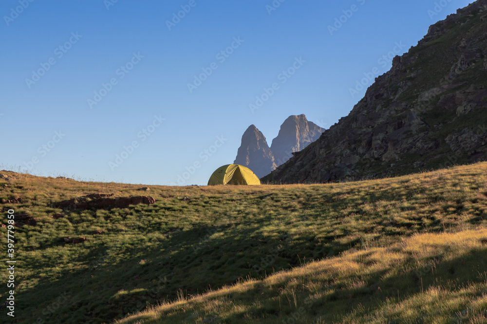 Obraz premium Tent in the mountains with mountains in the background. Lifestyle concept