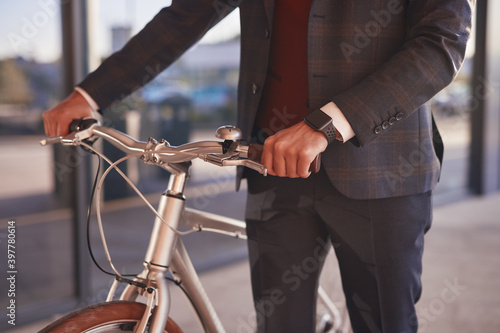 Elegant businessman with bicycle on street