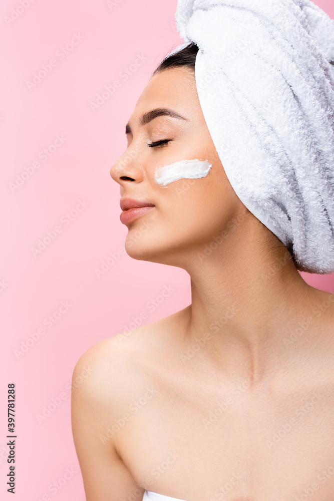 beautiful woman with towel on hair, closed eyes and cosmetic cream on face isolated on pink beautiful woman with towel on hair, closed eyes and cosmetic cream on face isolated on pink