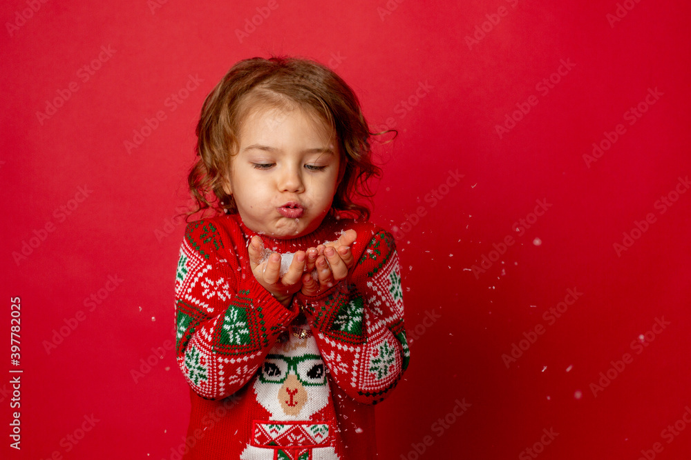 little girl blowing on snow red background Studio new year,christmas little girl blowing on snow red background Studio new year,christmas